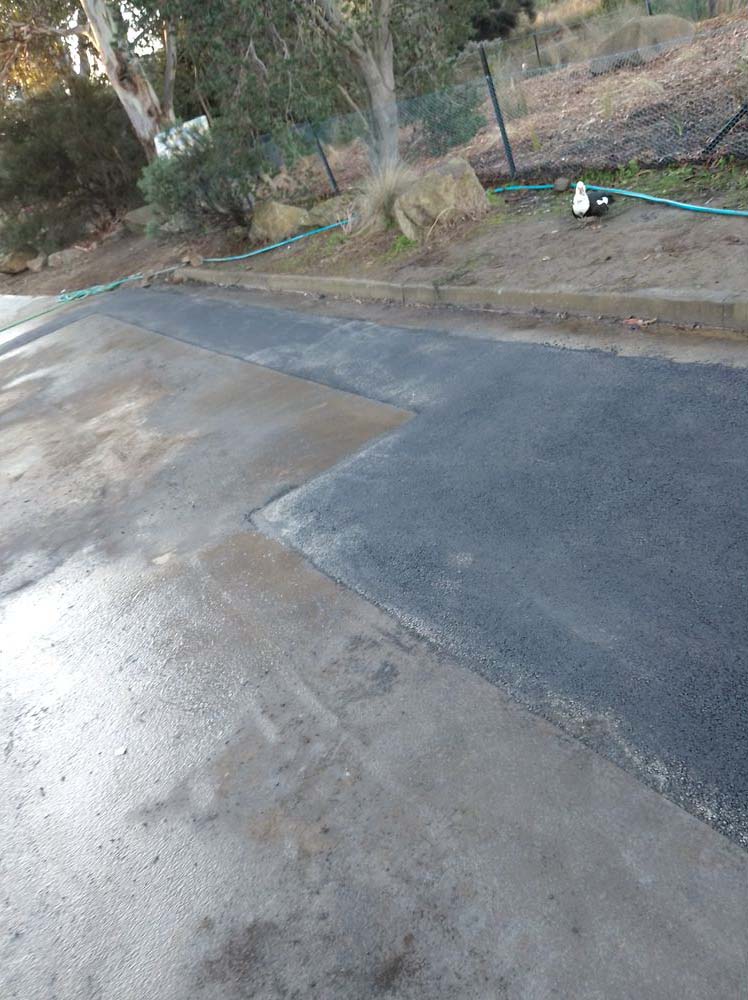 New concrete slab meeting an asphalt driveway