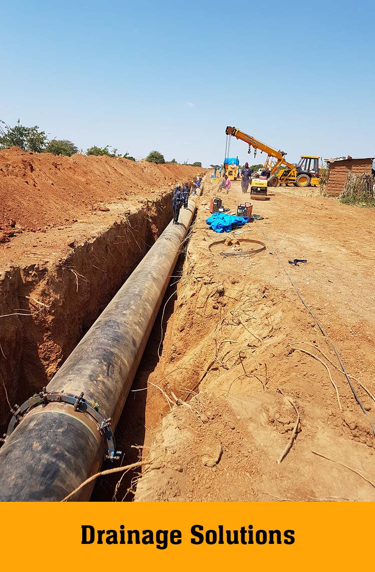 Large pipe laid in a long open trench, labelled Drainage Solutions