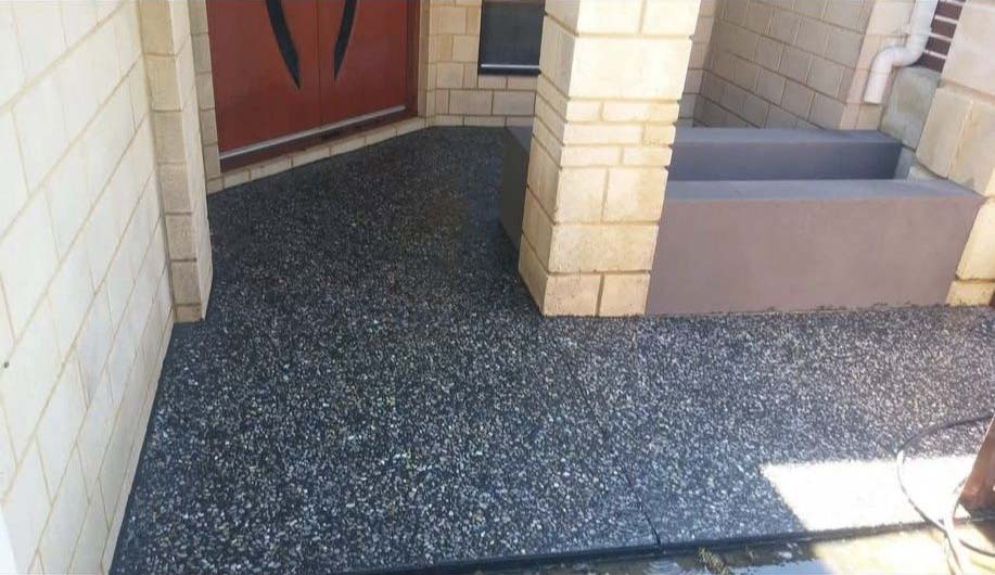 Exposed aggregate concrete path at a brick front entrance