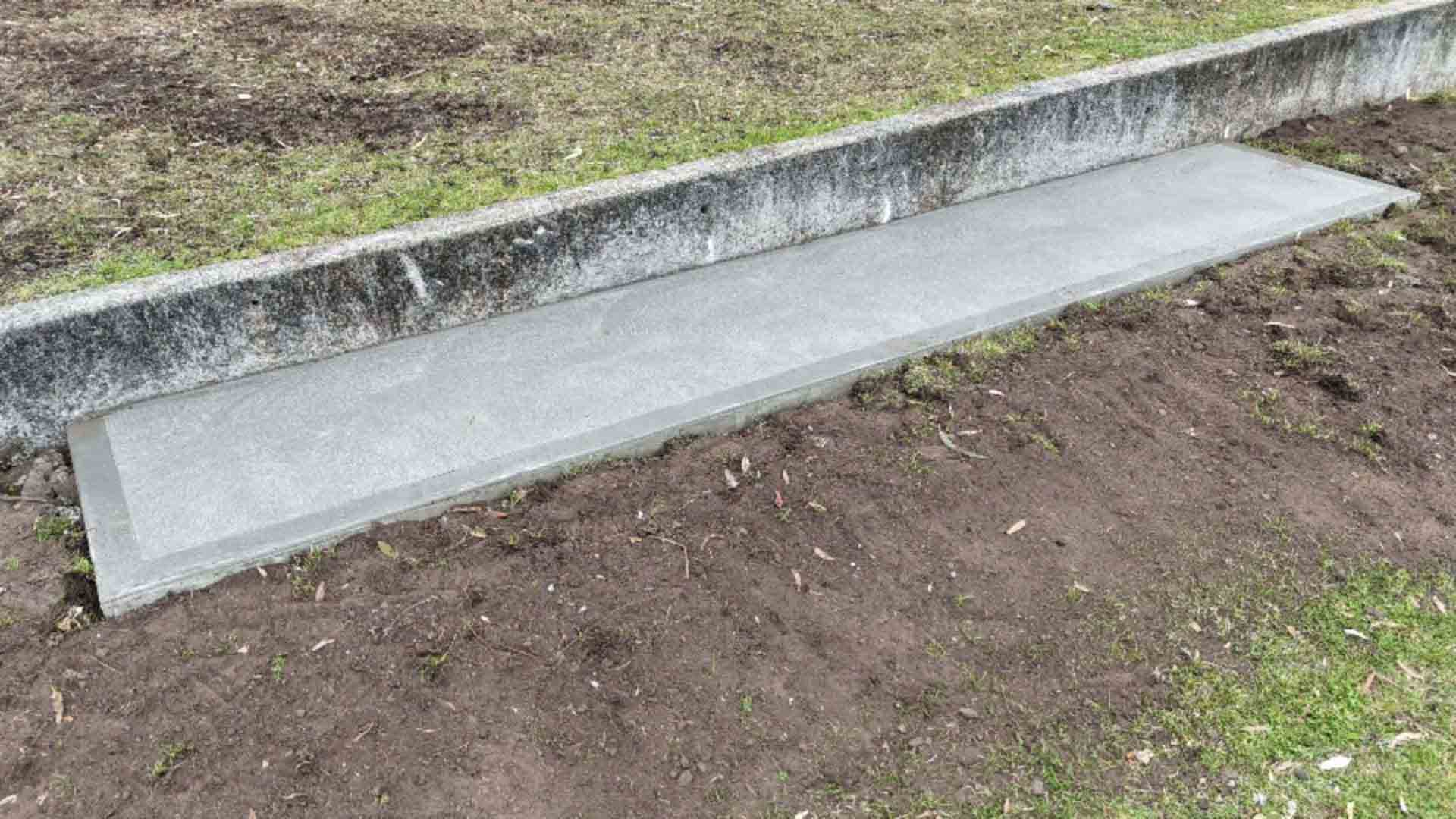 Long narrow concrete slab beside a low concrete wall