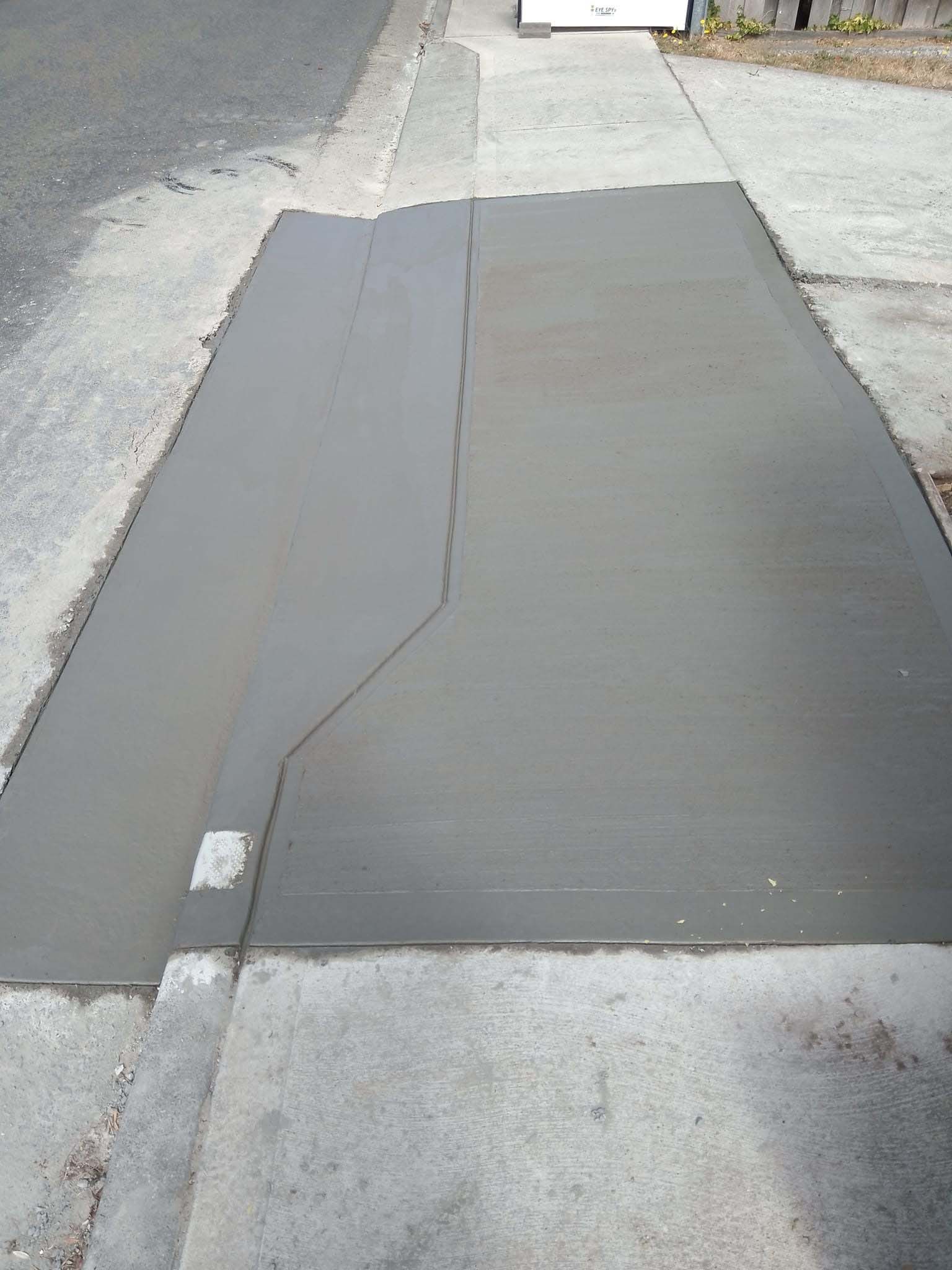 New concrete driveway crossover across a footpath, seen from above