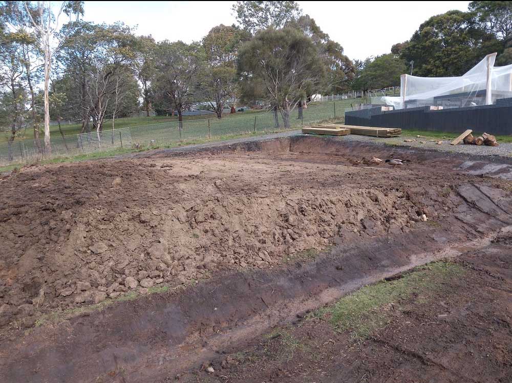 Large excavated dirt pad on a cleared block