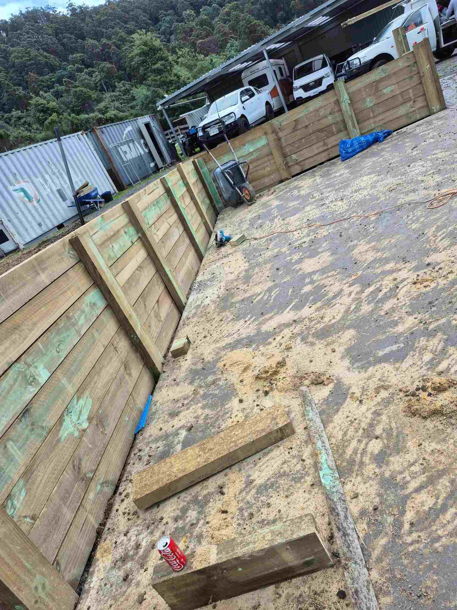 Timber sleeper retaining wall around a levelled sandy pad