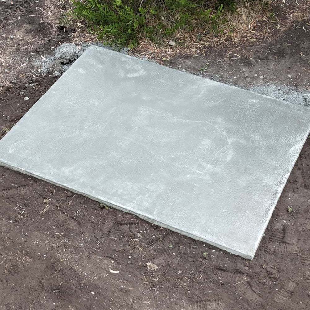 Small square concrete slab on bare soil